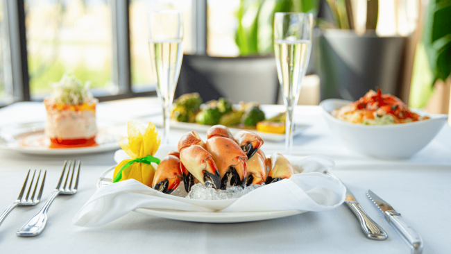 Fresh Florid stone crab claw entree on ice with a fresh lemon and champagne flutes