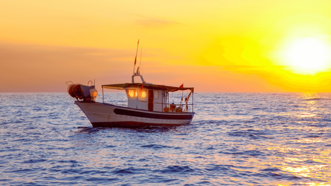 a stone crab boat out to sea during sunset