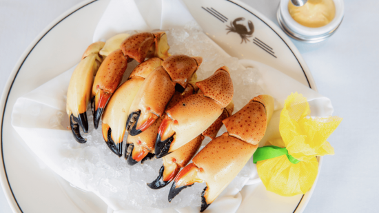 Florida stone crab claws entree platter with mustard sauce and a wrapped lemon