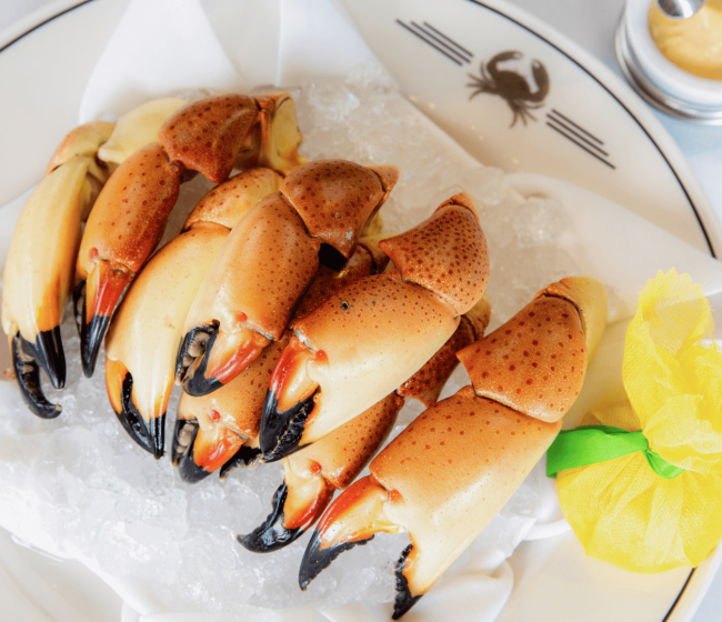 Florida stone crab claws entree platter with mustard sauce and a wrapped lemon