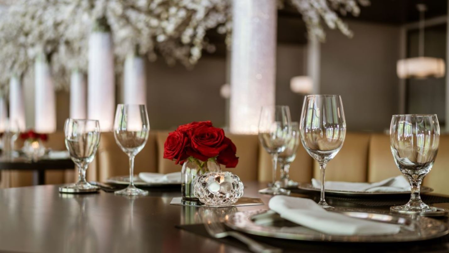 interior table setting austin downtown with red roses, wine glasses and crystal candle