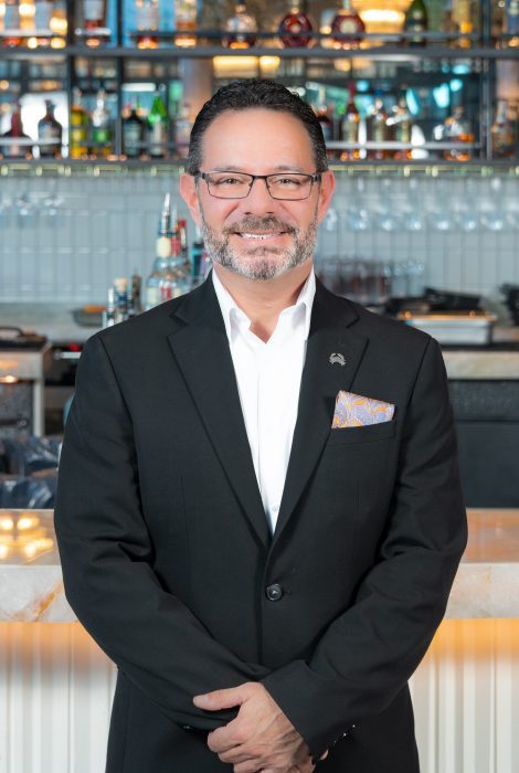 headshot of Mike Levine in a suit in front of th e bartop at the Fort Lauderdale location