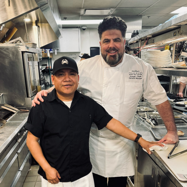 Keegan and a line cook in the kitchen posing on the line