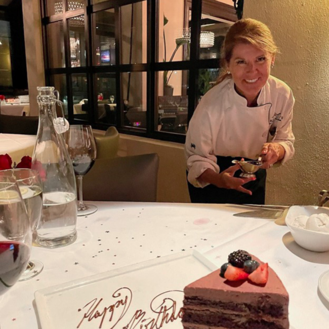 Heidi in Naples serving a dessert to a guest table with chocolate cake in the foreground