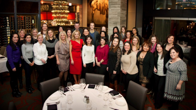 Shawn with the steakhouse ladies networking group in a dining room of a restaurant