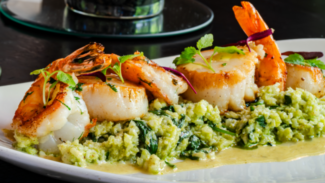 SCALLOP & SHRIMP SAUTE florentine cauliflower rice, lemon vinaigrette on a white china plate
