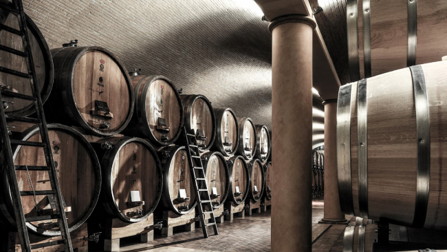 wine barrels stacked in a wine cave cooling area