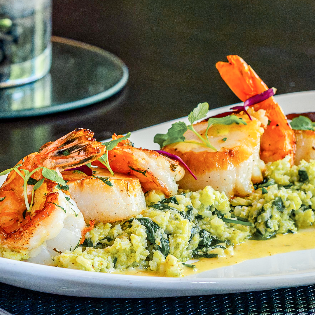 sauteed scallops and shrimp over cauliflower florentine style rice dressed in microgreens