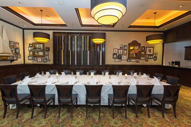 The Houston Naples room private room set up boardroom style with a wine wall in the background