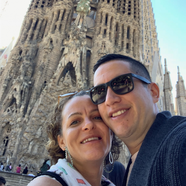 Fern and his wife traveling with an ancient church in the background.