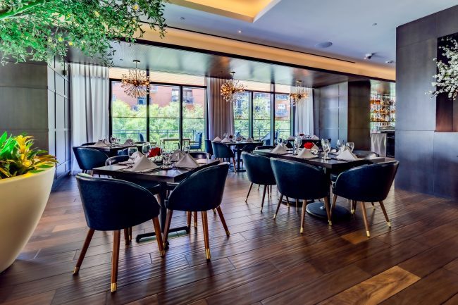 Truluck's Austin downtown upstairs mezzanine area with floor to ceiling windows on the far wall and sputnik style chandeliers.