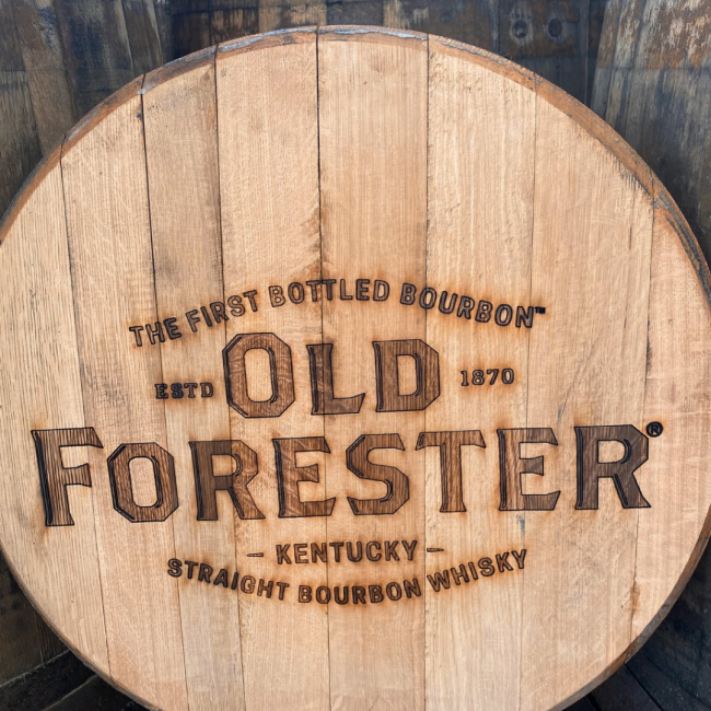 The first bottled bourbon estd 1870. Old Forester Kentucky, Straight Bourbon Whiskey branded into a round wood barrel top made of wood.