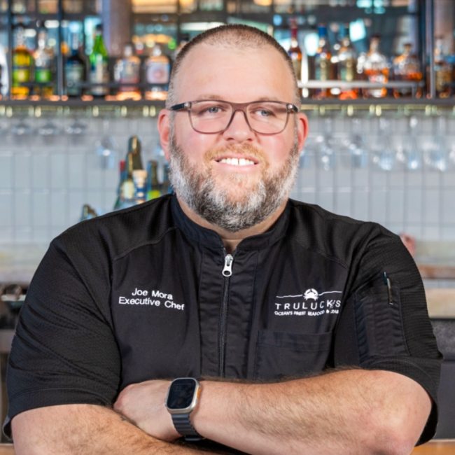 Chef Joe of Truluck's Fort Lauderdale standing in front of the bar with his arms crossed