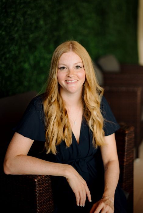 Headshot of Amanda Chambers, SEM in DC. Amanda in a navy dress with her arm on a chair.