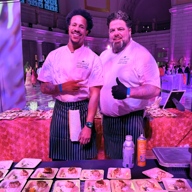 Chef Darryl and Keegan in chef coats at the Pink Tie Party offsite event