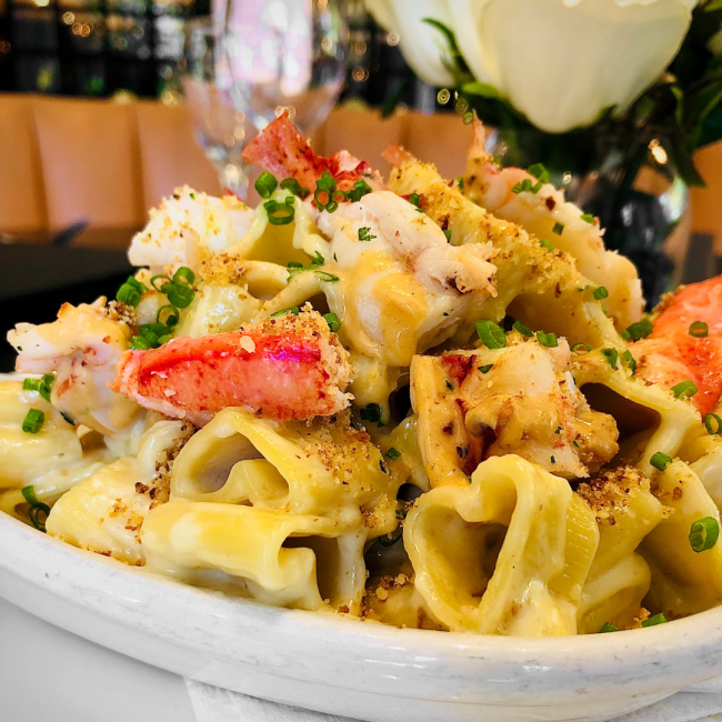 king crab macaroni and cheese with heart-shaped pasta and green chive garnish