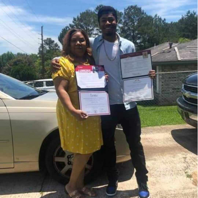 Chef Dom and his mother outside holding up Dom's diploma from culinary school.