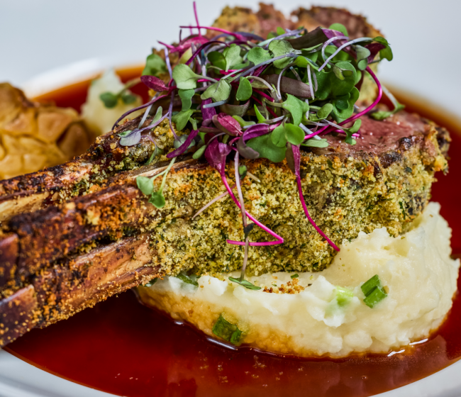 Lumina lamp chop at Truluck's served bone in with a dijon, herb and parmesan crust atop parmesan mashed potatoes and a rosemary shallot demi glace topped with fresh microgreens