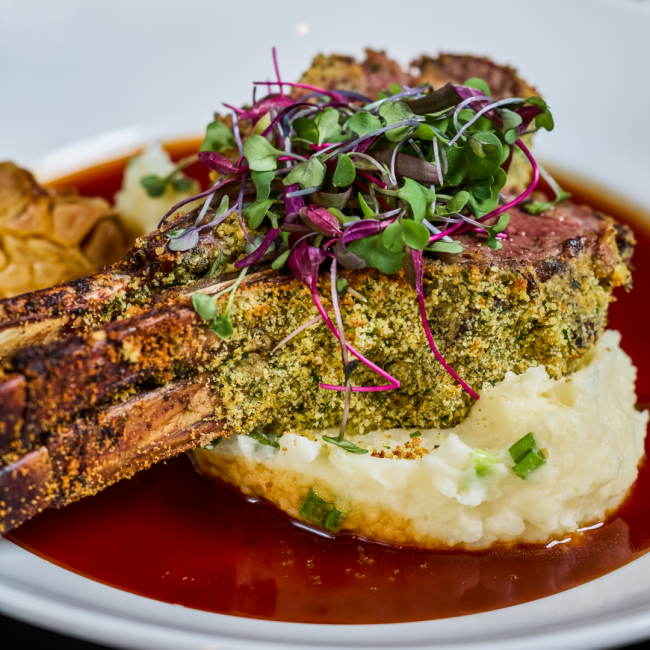 Lumina lamp chop at Truluck's served bone in with a dijon, herb and parmesan crust atop parmesan mashed potatoes and a rosemary shallot demi glace topped with fresh microgreens