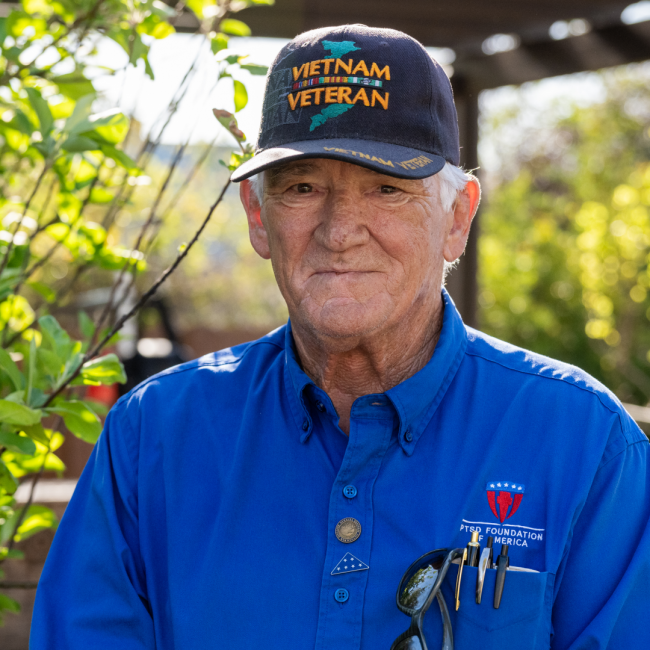 Phil a Vietnam Veteran mentor of PTSD Foundation of America's Camp Hope dressed in a blue button up shirt and ball cap with "Vietnam Veteran" written on the front