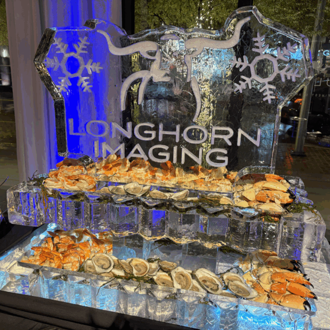 an ice sculpture with "longhorn imaging" carved in ice with a longhorn and snowflake shapes. The bottom of the ice sculpture is two ice shelves filled with fresh oysters, stone crab claws and cocktail shrimp