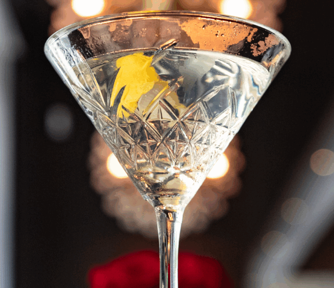 a crystal martini glass filled with chilled vodka and a lemon twist