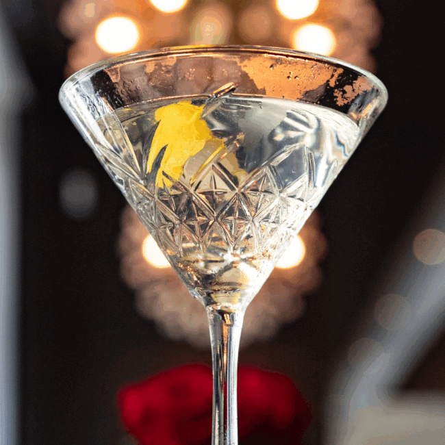 a crystal martini glass filled with chilled vodka and a lemon twist