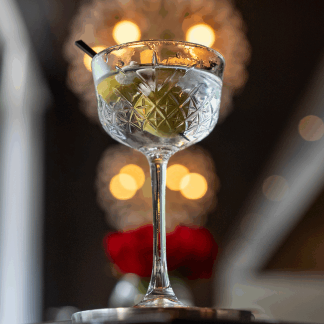 A tiny tini version of the dinner martin in a chilled crystal glass with blue cheese stuffed olives