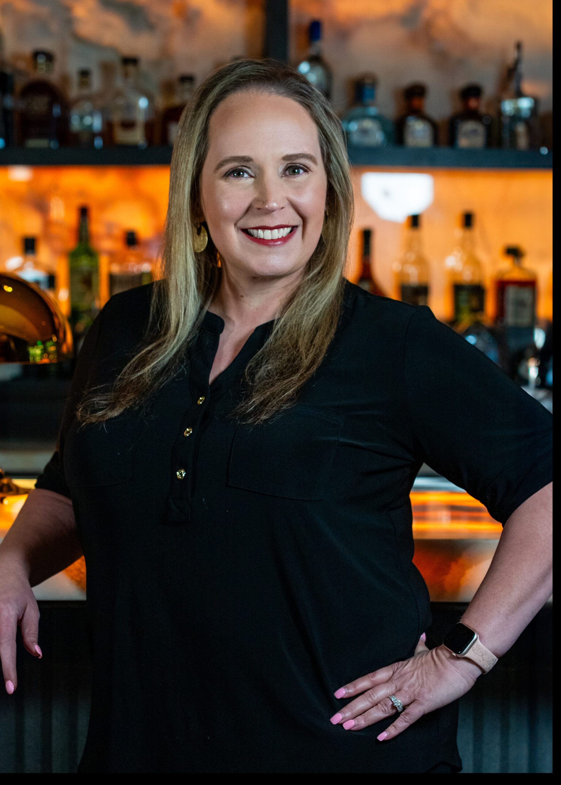 headshot of Misty Montague of Truluck's Austin in a black blouse posing in front of the bar top with one arm on the bartop and one hand on her hip