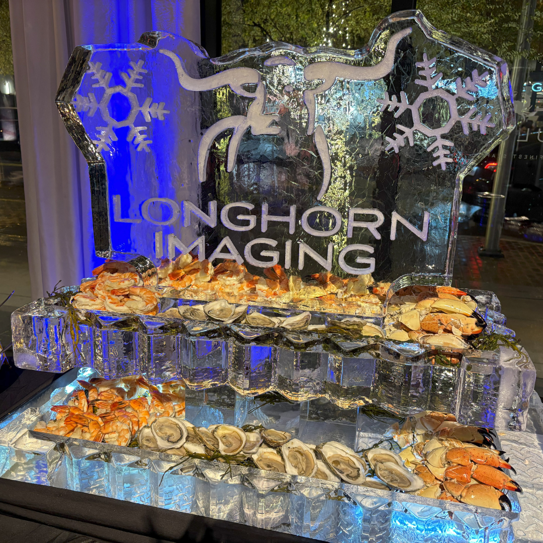 an ice sculpture with "longhorn imaging" carved in ice with a longhorn and snowflake shapes. The bottom of the ice sculpture is two ice shelves filled with fresh oysters, stone crab claws and cocktail shrimp