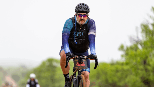 Ryan Studt on his bicycle during a bike race wearing a bike helmet and cycling attire