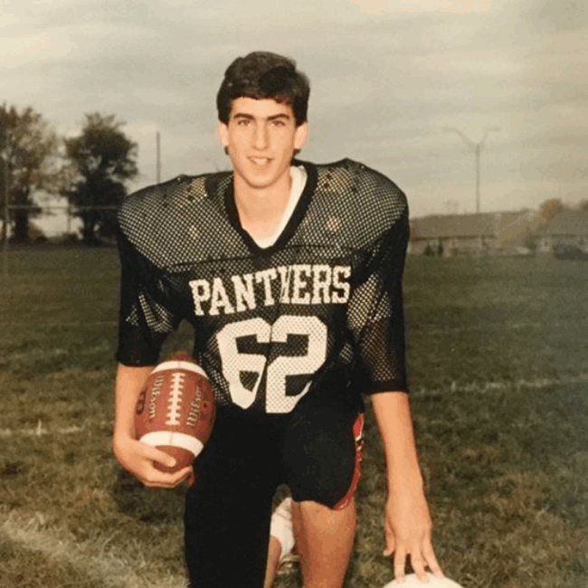 Ryan Studt general manager as a young high school football player posed in uniform for the Panthers football team and holding a football