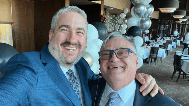 Ryan Studt general manager of Truluck's Dallas with colleague Brian Perry standing in the Dallas main dining room with silver and white balloons in the background