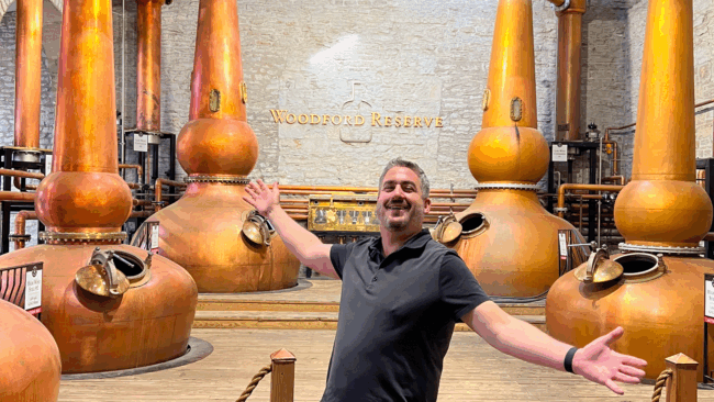 Ryan Studt in the Woodford Reserve distillery facility with whiskey stills in the background