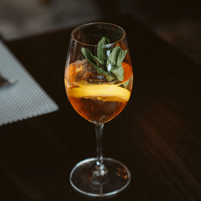 Non-alcoholic Pure Spritz made with alcohol-free sparkling wine and Ritual Aperitif, served over ice with citrus and fresh mint.