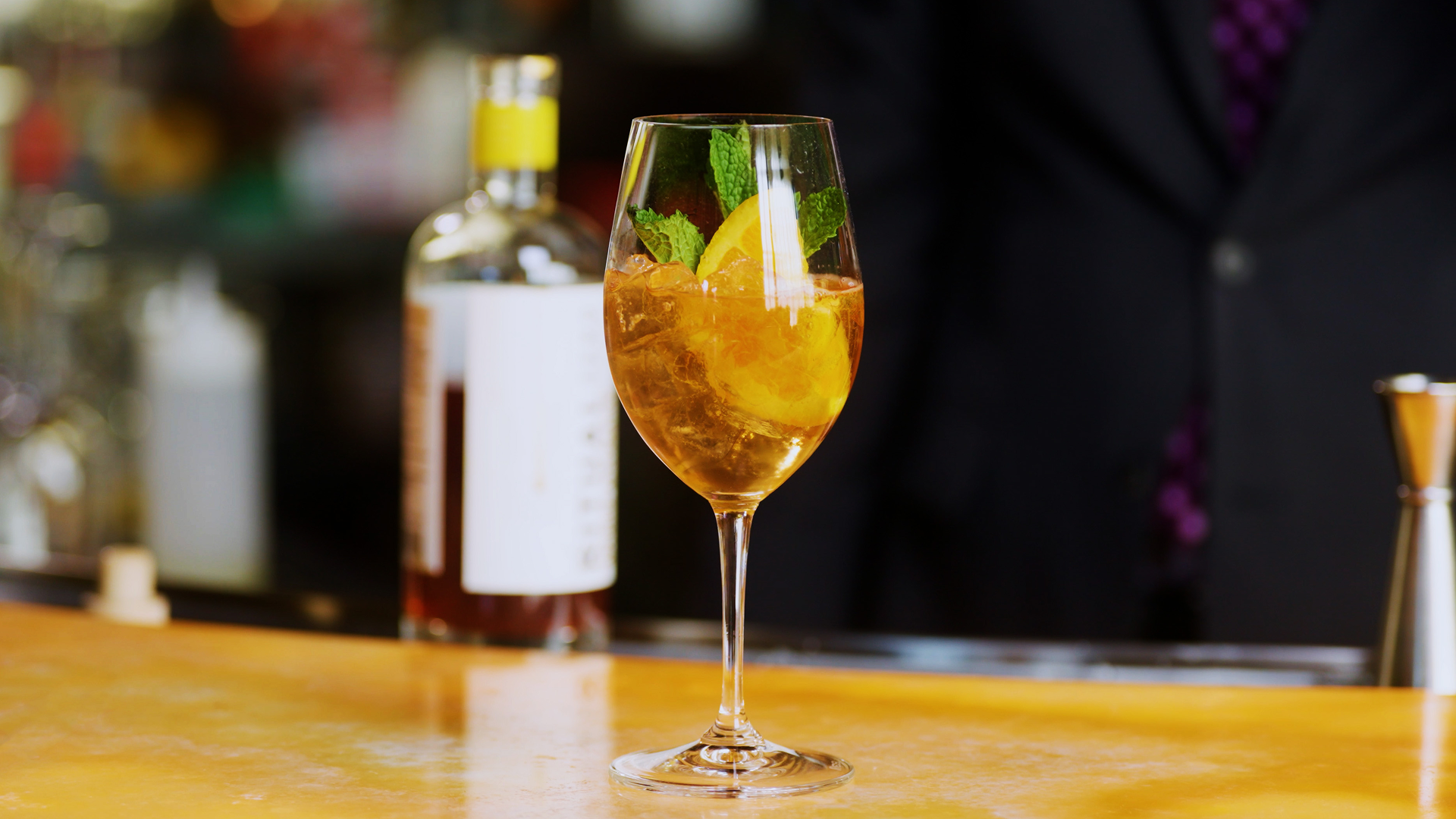 Golden non-alcoholic Pure Spritz featuring alcohol-free sparkling bubbles and Ritual Aperitif, garnished with citrus and mint.
