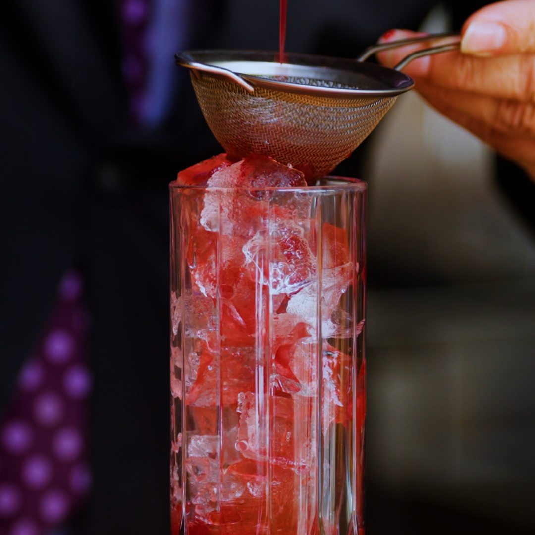 Non-alcoholic Blackberry Bramble with blackberry, habanero, fresh lime, and soda water, strained over ice in a tall glass.