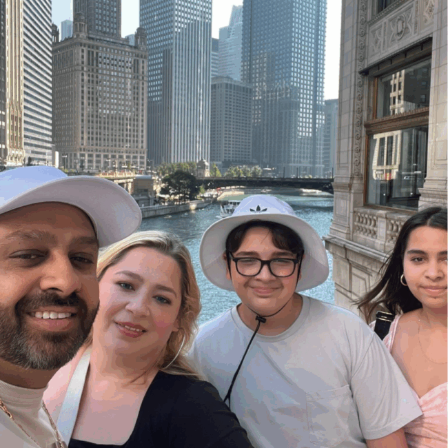 Blake Goldie is spending time with his family in downtown Chicago, standing along the river with iconic city buildings behind them