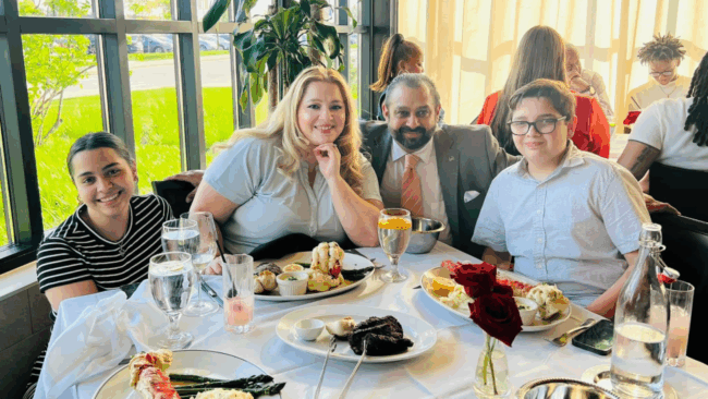 Blake of Truluck's Rosemont with his wife and two children sitting at a dining table in Truluck's dining room enjoying dinner together