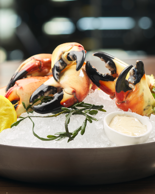 Chilled Florida Stone Crab claws served over crushed ice with lemon, seaweed garnish, and Truluck’s signature mustard sauce.