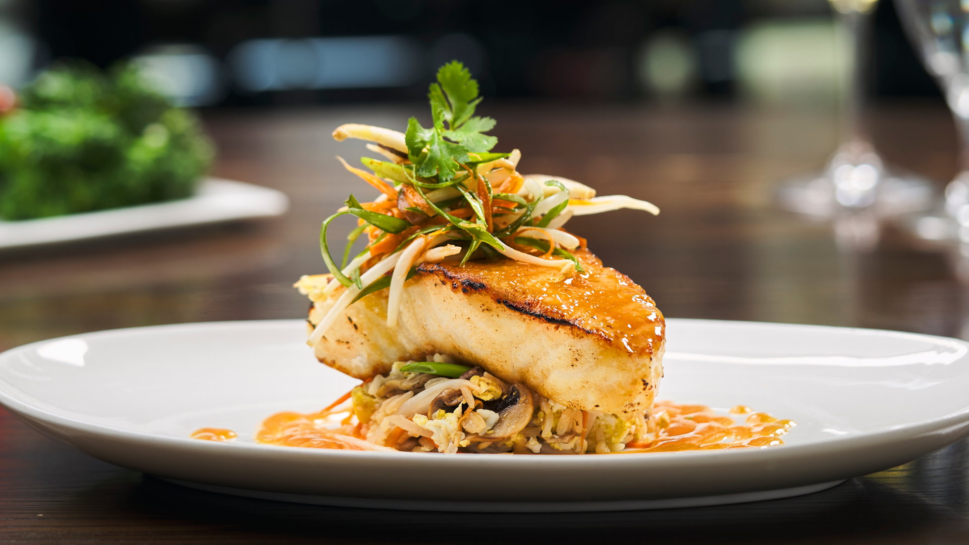 Truluck's Miso-Glazed Sea Bass served with stir-fried vegetables and citrus glaze — one of Truluck's signature seafood entrées available across all six locations during the 2026 FIFA World Cup