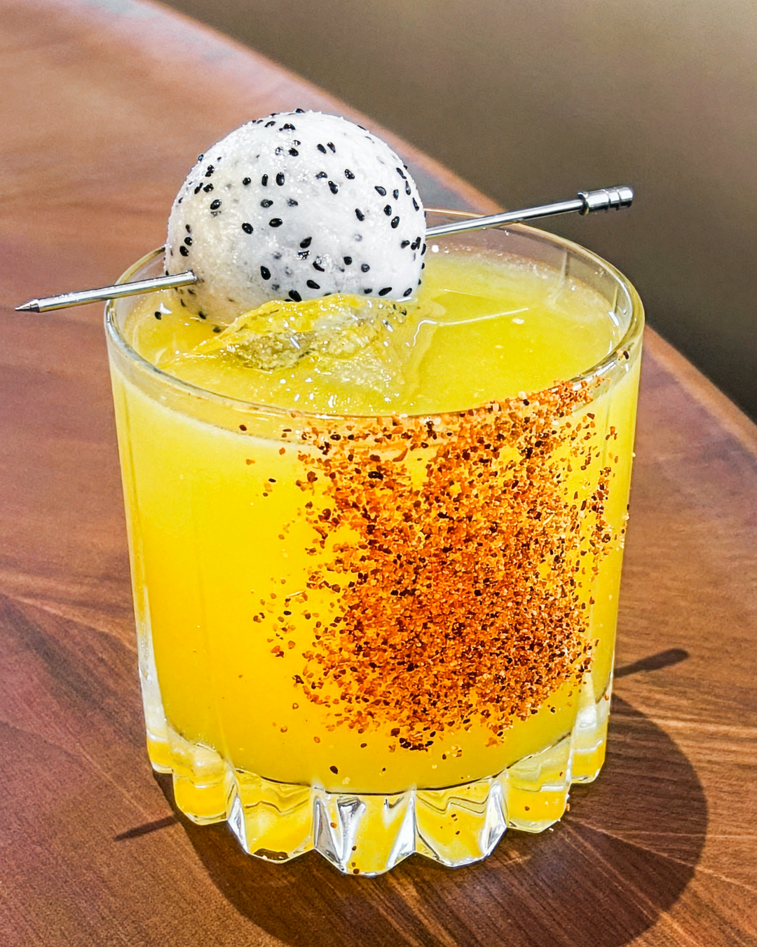 A Truluck's signature cocktail with mango, Tajín spice rim, and dragon fruit garnish — part of the seasonal cocktail menu available during World Cup match weeks