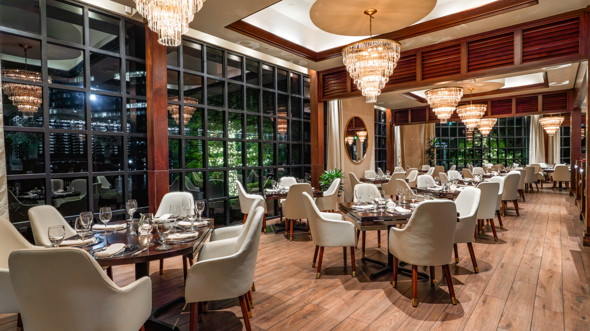 The main dining room at Truluck's The Woodlands at 1900 Hughes Landing Boulevard, featuring crystal chandeliers and floor-to-ceiling windows overlooking Lake Woodlands