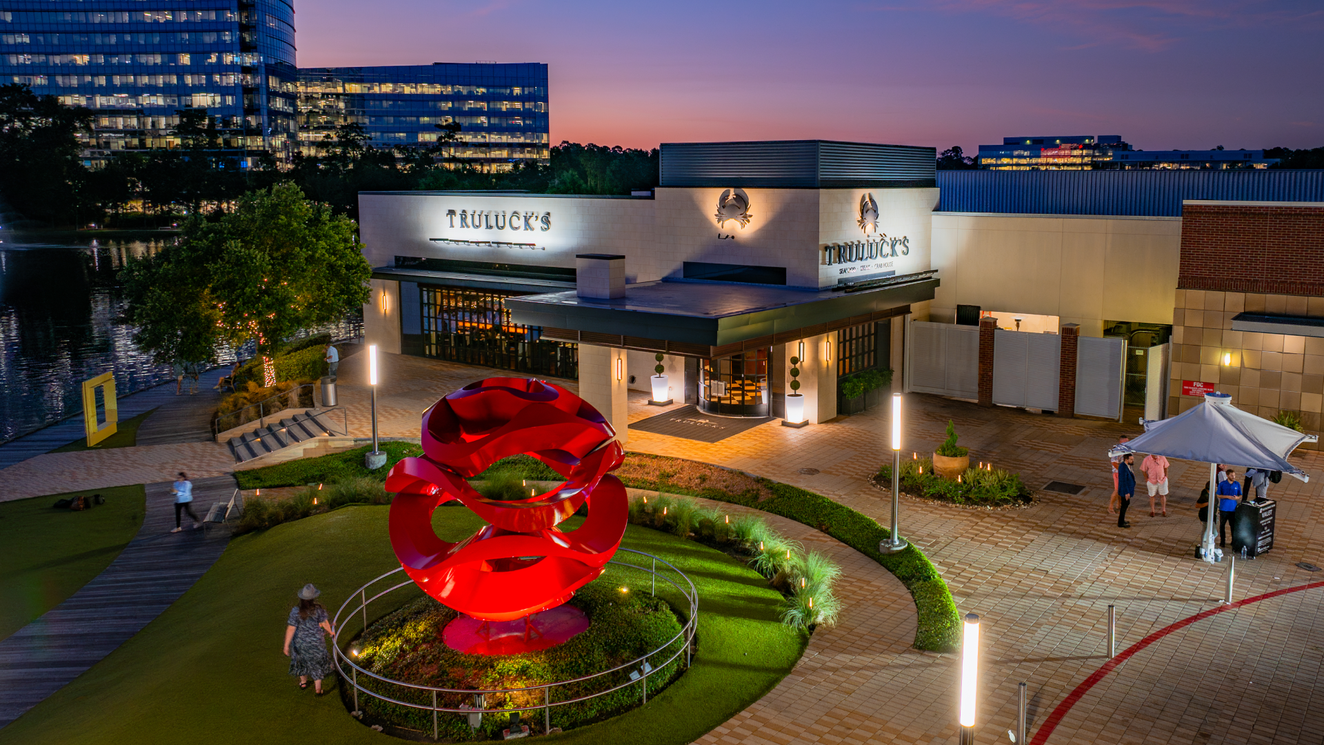 Truluck's The Woodlands exterior at Hughes Landing on Lake Woodlands at sunset, the North Houston fine dining destination 45 minutes from NRG Stadium during the 2026 FIFA World Cup
