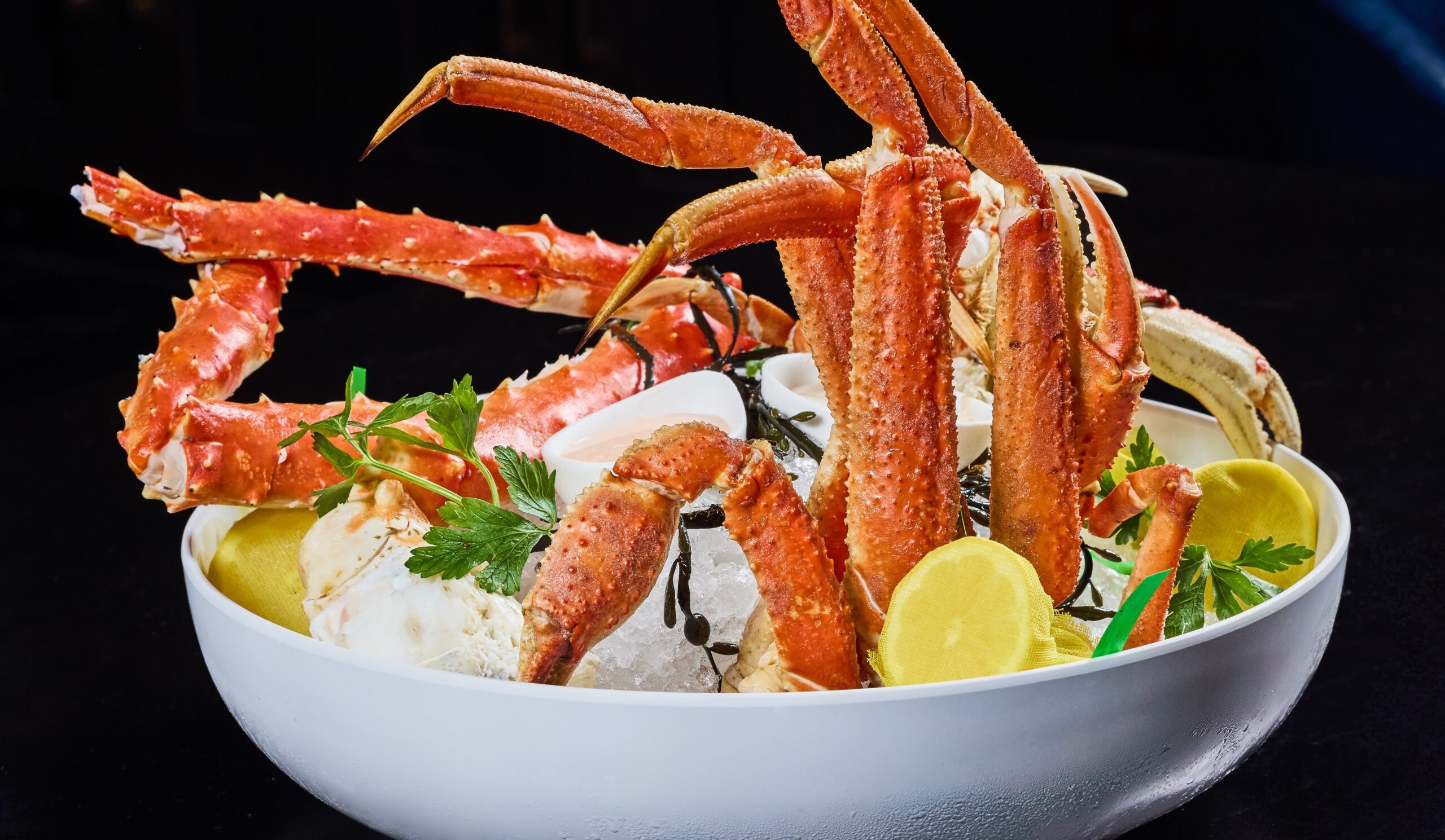 Crab Crab Crab flight with Dungeness, Bairdi and Alaskan king crab legs served chilled over crushed ice with lemon, parsley, and house specialty mustard sauce