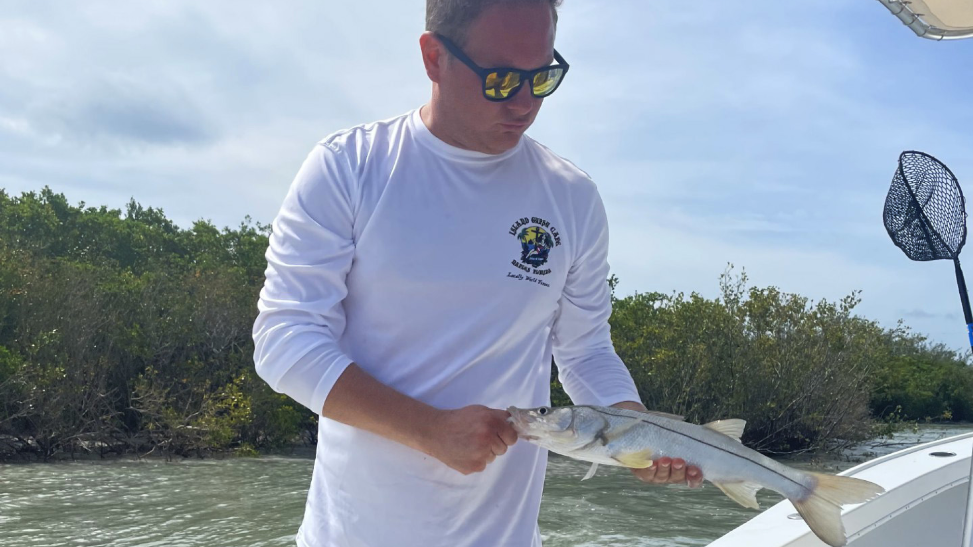 Johnny Griesedieck, General Manager of Truluck’s Naples, holding a fish while out on the water in Southwest Florida.