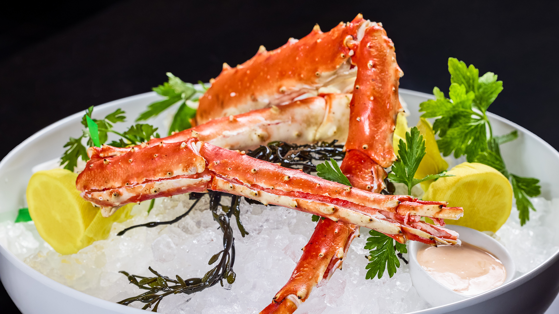 Alaskan king crab legs served chilled over crushed ice with lemon, parsley, seaweed, and house specialty mustard sauce.